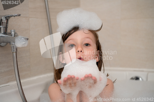 Image of little girl in bath playing with foam