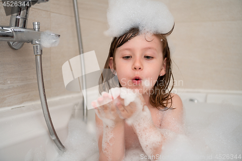 Image of little girl in bath playing with foam