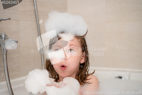 Image of little girl in bath playing with foam