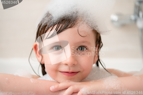 Image of little girl in bath playing with foam