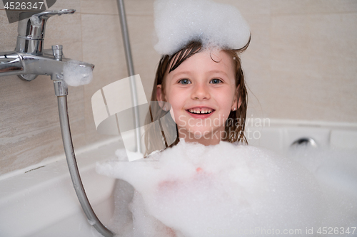 Image of little girl in bath playing with foam