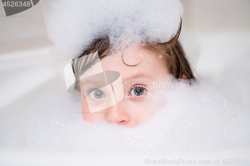 Image of little girl in bath playing with foam