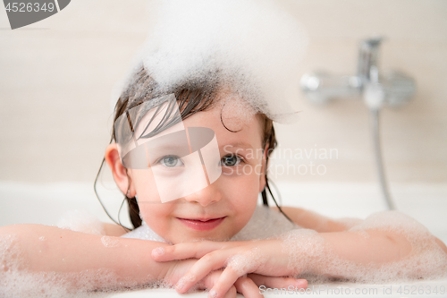 Image of little girl in bath playing with foam