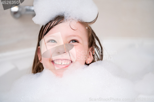 Image of little girl in bath playing with foam