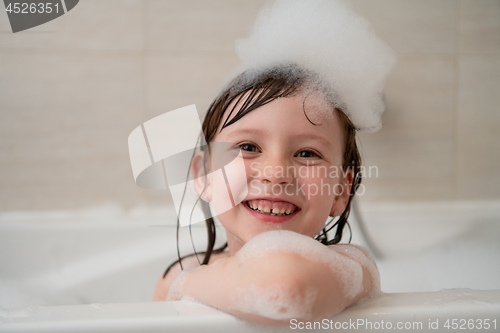 Image of little girl in bath playing with foam