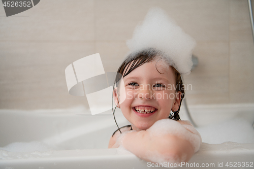 Image of little girl in bath playing with foam