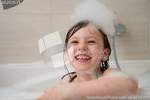 Image of little girl in bath playing with foam