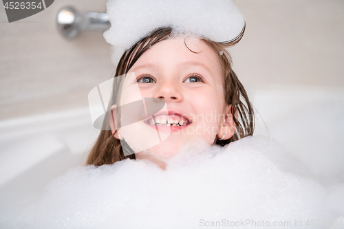 Image of little girl in bath playing with foam