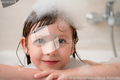 Image of little girl in bath playing with foam