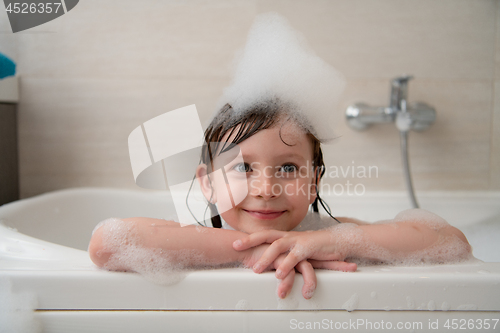 Image of little girl in bath playing with foam