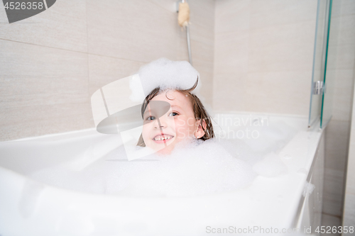 Image of little girl in bath playing with foam