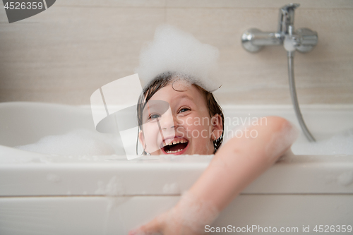 Image of little girl in bath playing with foam