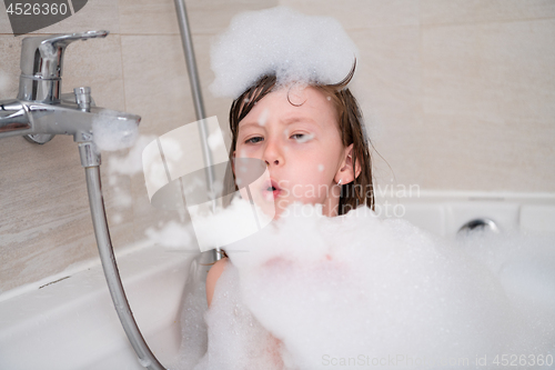 Image of little girl in bath playing with foam