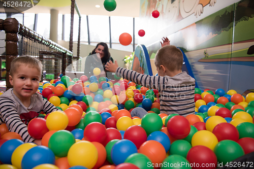 Image of Young mom with her kids in a children\'s playroom