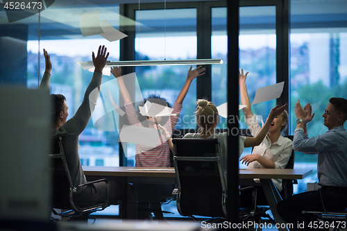 Image of multiethnic Group of young business people throwing documents