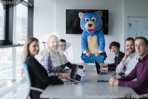 Image of boss dresed as bear having fun with business people in trendy of