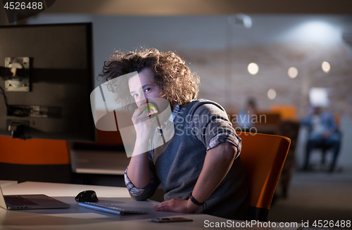Image of man eating apple in his office