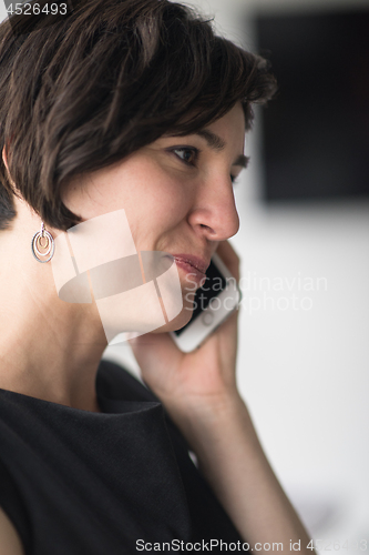 Image of Elegant Woman Using Mobile Phone in office building