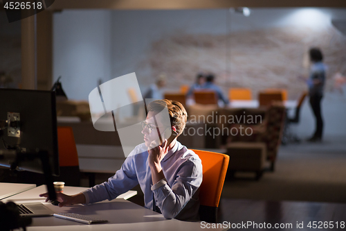 Image of man using mobile phone in dark office