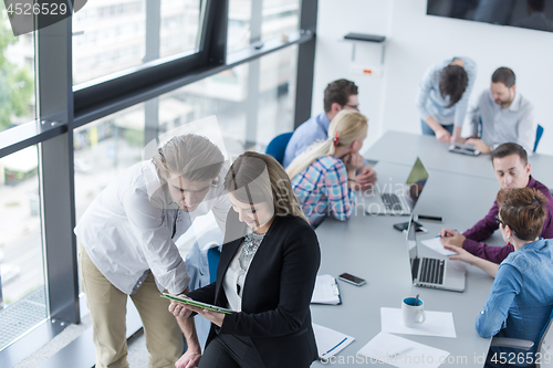 Image of Two Business People Working With Tablet in office