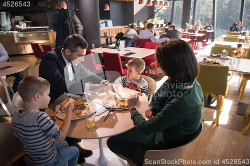 Image of Young parents enjoying lunch time with their children