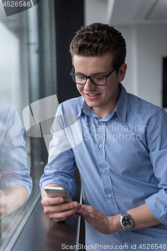 Image of Businessman Standing In A Modern Building Near The Window With P