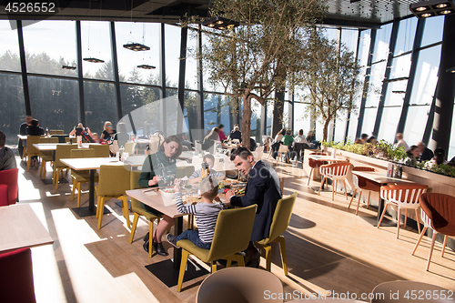 Image of Young parents enjoying lunch time with their children