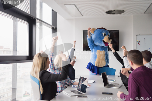 Image of boss dresed as bear having fun with business people in trendy of