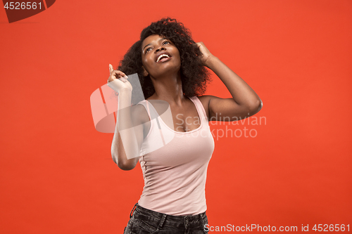 Image of The happy african woman standing and smiling against red background.