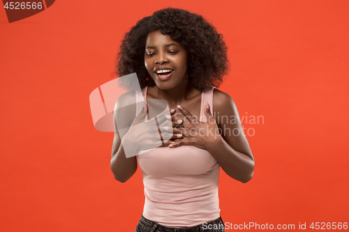 Image of The happy african woman standing and smiling against red background.