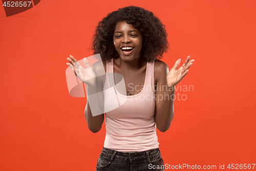 Image of The happy african woman standing and smiling against red background.