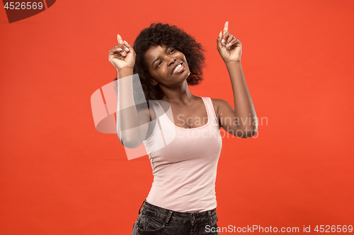 Image of The happy african woman standing and smiling against red background.