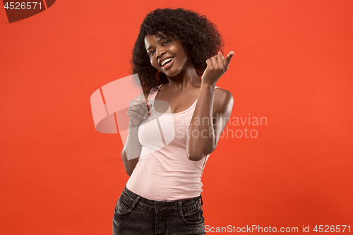 Image of The happy african woman standing and smiling against red background.
