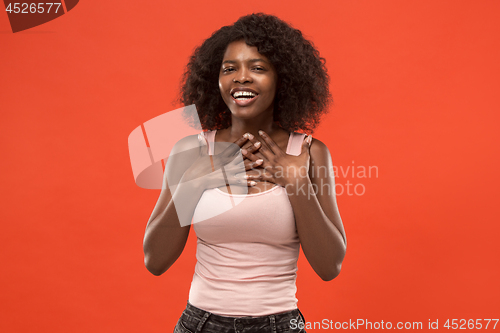 Image of The happy african woman standing and smiling against red background.