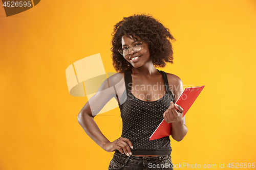 Image of portrait of a beautiful friendly African American woman with a curly afro hairstyle and red folder