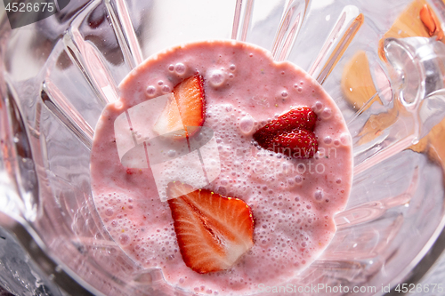 Image of healthy red smoothie with strawberries, yoghurt and chia seeds in glass jars blender, top view