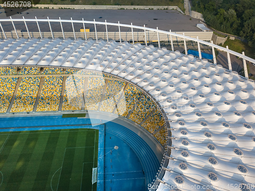 Image of KYIV, UKRAINE - July 19, 2018. Aerial view from drone of construction of the stadium cover, green football field, tribunes of NSC Olimpiysky.