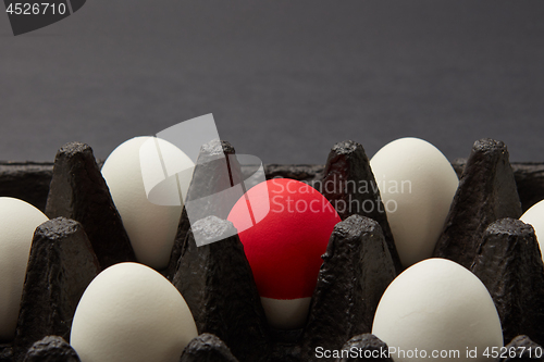 Image of Closeup of black cardboard box with white and red raw eggs on black background with copy space. Easter concept