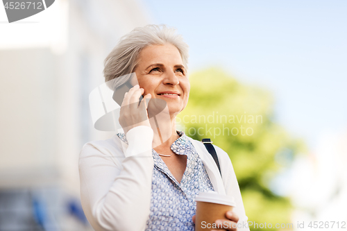 Image of senior woman calling on smartphone in city