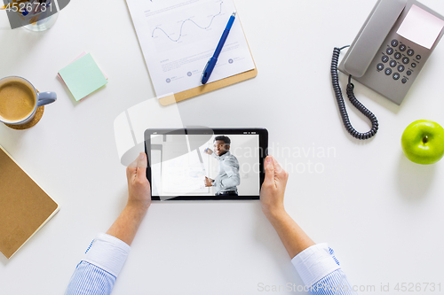 Image of hands of businesswoman watching webinar on tablet