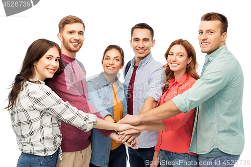 Image of group of smiling friends stacking hands