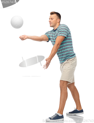 Image of smiling young man playing volleyball