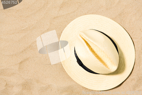 Image of straw hat on beach sand