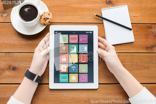 Image of hands with smart home icons on tablet computer