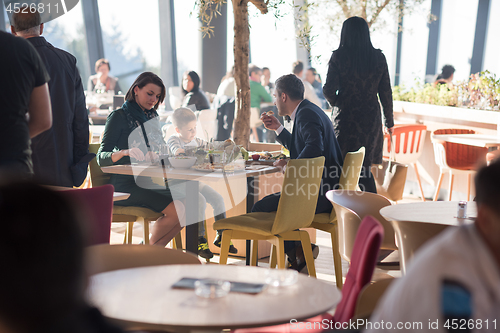 Image of Young parents enjoying lunch time with their children