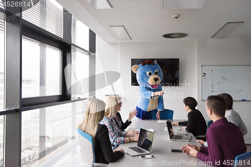 Image of boss dresed as bear having fun with business people in trendy of