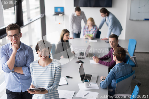 Image of Two Business People Working With Tablet in office