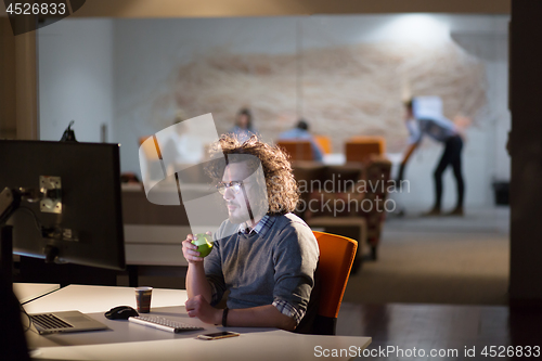 Image of man working on computer in dark office