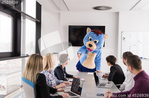 Image of boss dresed as bear having fun with business people in trendy of