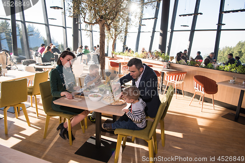 Image of Young parents enjoying lunch time with their children